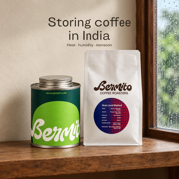 Bermito’s green coffee tin and white coffee pouch stored closed on a shaded wooden shelf, with monsoon rain outside.